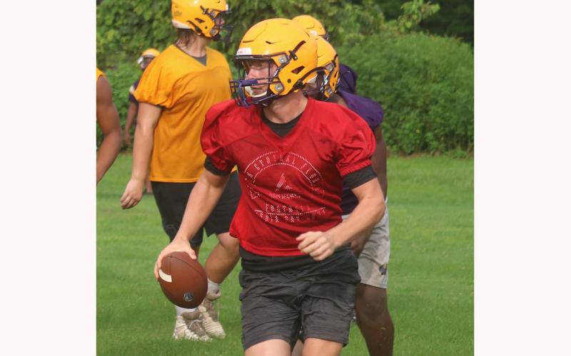 Columbia quarterbacks Kade Jackson looks down the field to throw as he escapes pressure from the defense during practice on Tuesday. (JORDAN KROEGER/Lake City Reporter)