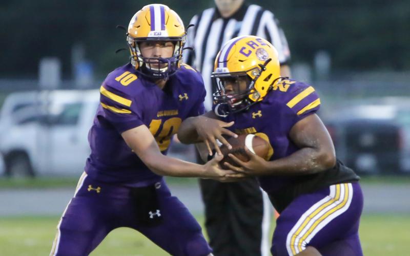 Columbia quarterback Kade Jackson hands the ball off to running back Tony Fulton against Bolles on Sept. 3. (BRENT KUYKENDALL/Lake City Reporter)