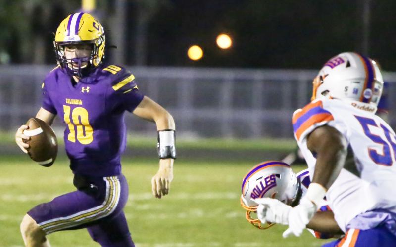 Columbia quarterback Kade Jackson scrambles away from pressure against Bolles on Friday night. (BRENT KUYKENDALL/Lake City Reporter)