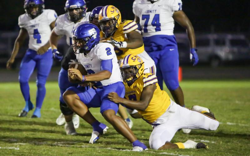 Columbia defensive end Adeon Farmer (7) attempts to tackle Trinity Christian quarterback Colin Hurley as defensive tackle Garris Reed (58) gives chase last Friday. (BRENT KUYKENDALL/Lake City Reporter)
