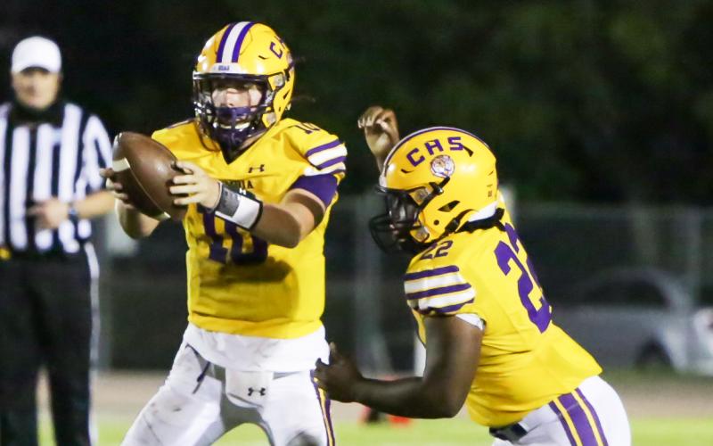 Columbia quarterback Kade Jackson takes a snap before handing the ball off to running back Tony Fulton against Trinity Christian on Friday. (BRENT KUYKENDALL/Lake City Reporter)