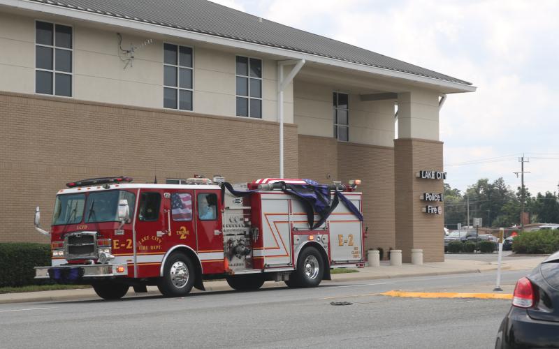 A Lake City fire truck carrying Randy Burnham, the city’s fallen fire chief, passes by the Lake City Fire Department Station 1 on Friday afternoon on its way to the Corinth Methodist Church cemetery. (JAMIE WACHTER/Lake City Reporter)