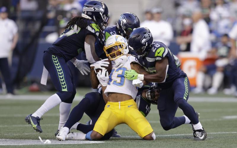 Los Angeles Chargers wide receiver Tyron Johnson, center, is brought down by Seattle Seahawks' Marquise Blair, Damarious Randall and Ugo Amadi, from left, during a preseason game on Aug. 28 in Seattle. (JOHN FROSCHAUER/Associated Press)