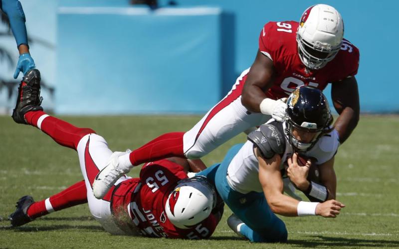 Arizona Cardinals linebacker Chandler Jones (55) and defensive end Michael Dogbe (91) tackle Jacksonville Jaguars quarterback Trevor Lawrence on Sept. 26 in Jacksonville. (STEPHEN B. MORTON/Associated Press)