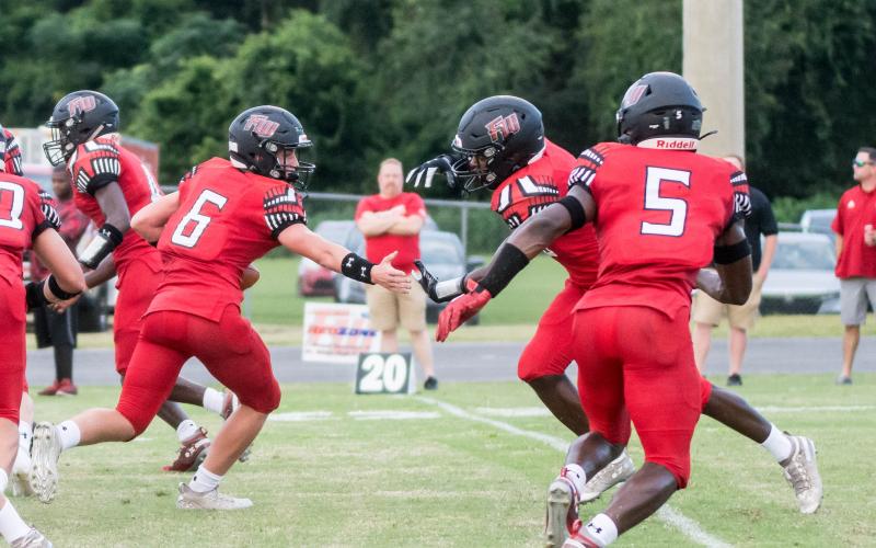 Fort White quarterback Clayton Philpot fakes a handoff to running back Darren Clark during their Preseason Classic against Middleburg on Aug. 20. (CHRISTINA FEAGIN/Special to the Reporter)