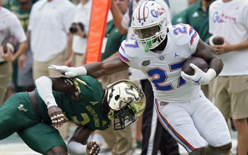 Florida running back Dameon Pierce gets past South Florida safety Vincent Davis on a run on Sept. 11 in Tampa. (CHRIS O'MEARA/Associated Press)