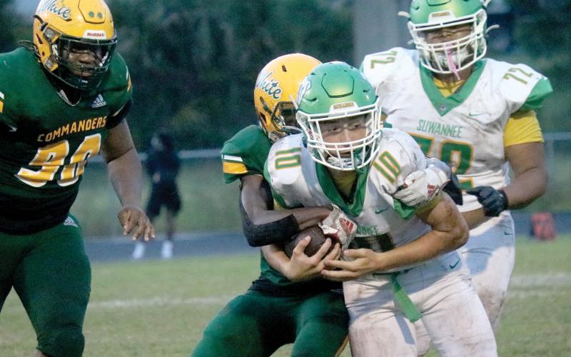 Suwannee quarterback Kodi Lang gets tackled by Ed White on Friday night. (JAMIE WACHTER/Lake City Reporter)
