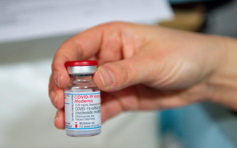A health care professional holds a vial of the Moderna covid-19 vaccine on April 7 in Carmarthen, Wales. (JACOB KING/POOL/AFP via Getty Images)