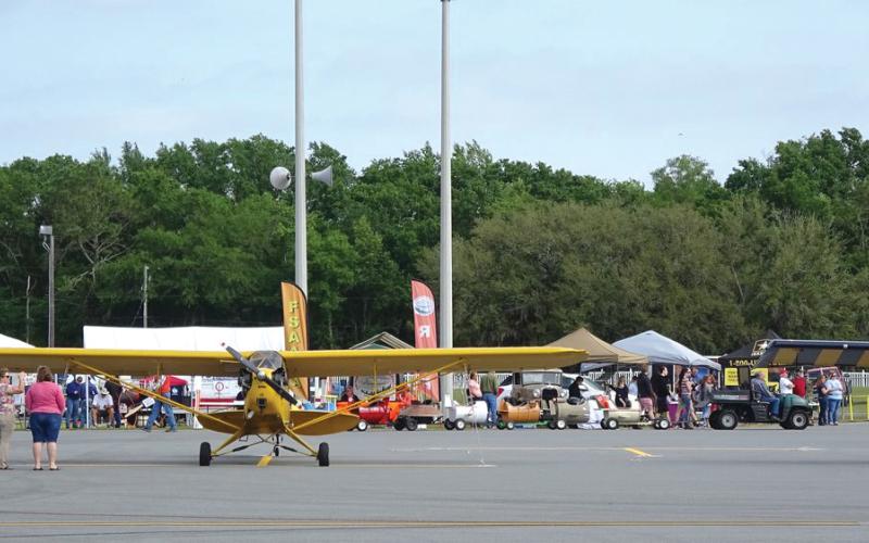 Spectators gather around a yellow airplane at a previous Wings Over Suwannee event at the Suwannee County Airport. (COURTESY)