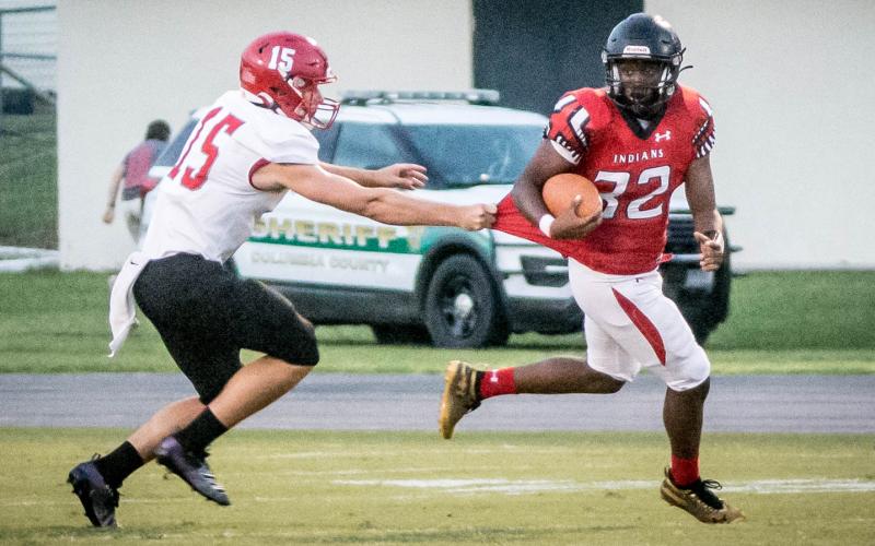 Fort White running back Kamarion Griffin escapes a tackle against Santa Fe on Friday night. (CHRISTINA FEAGIN/Special to the Reporter)