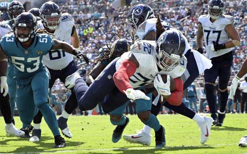 Tennessee Titans running back Derrick Henry dives for a touchdown past Jacksonville Jaguars linebacker Dakota Allen on Oct. 10 in Jacksonville. (PHELAN M. EBENHACK/Associated Press)