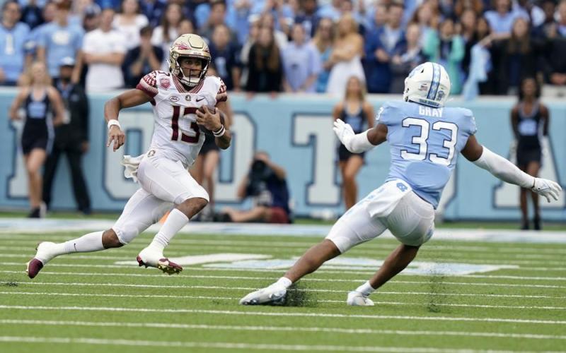 Florida State quarterback Jordan Travis (13) runs the ball against North Carolina linebacker Cedric Gray (33) on Oct. 9 in Chapel Hill, N.C. (GERRY BROOME/Associated Press)