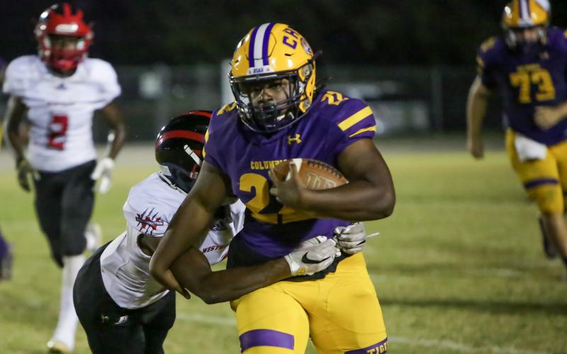 Columbia running back Tony Fulton tries to run through a tackle against Westside on Friday. (BRENT KUYKENDALL/Lake City Reporter)