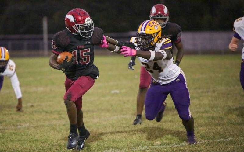 Raines’ Travis Laster stiff-arms Columbia linebacker Desavion Lee on Thursday. (BRENT KUYKENDALL/Lake City Reporter)