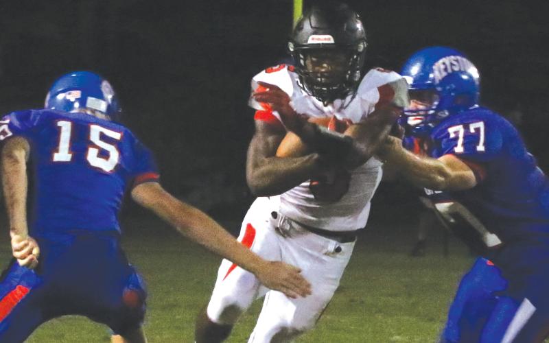 Fort White running back Darren Clark runs past Keystone Heights defensive lineman Trey Jeffries on Oct. 1. (MORGAN MCMULLEN/Lake City Reporter)