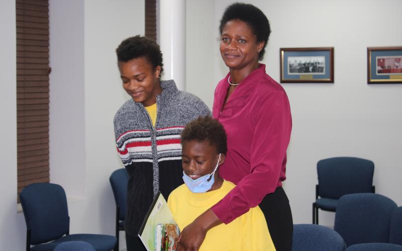 Befaithful Coker (right) stands with her two children, Victoria and Michael, in the council chambers. (TONY BRITT/Lake City Reporter)