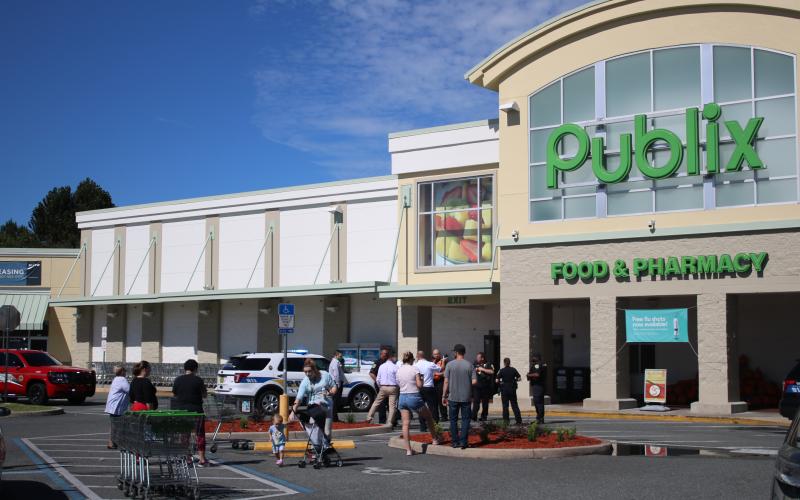 First responders hold potential customers outside at the Publix at 255 NW Commons Loop after a maintenance worker passed out and later died. (TONY BRITT/Lake City Reporter)