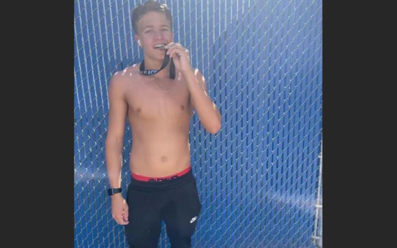 Suwannee swimmer poses with his first-place medal after winning the District 3-2A title in the 50 freestyle. (COURTESY)
