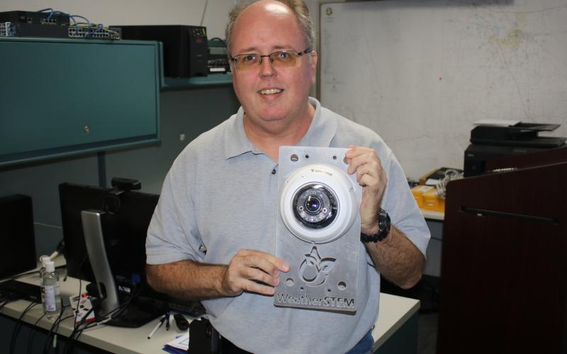 Shayne Morgan, Columbia County Emergency Management director, holds a WeatherSTEM monitor that was struck by lightning earlier this year. (TONY BRITT/Lake City Reporter)
