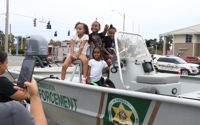 Lauryelle Broome (from left), Melissa Wright, Lavell Broome and Millicent Wright explore a Florida Fish and Wildlife Commission law enforcement boat Tuesday night at the National Night Out event in downtown Lake City. (MORGAN MCMULLEN/Lake City Reporter)