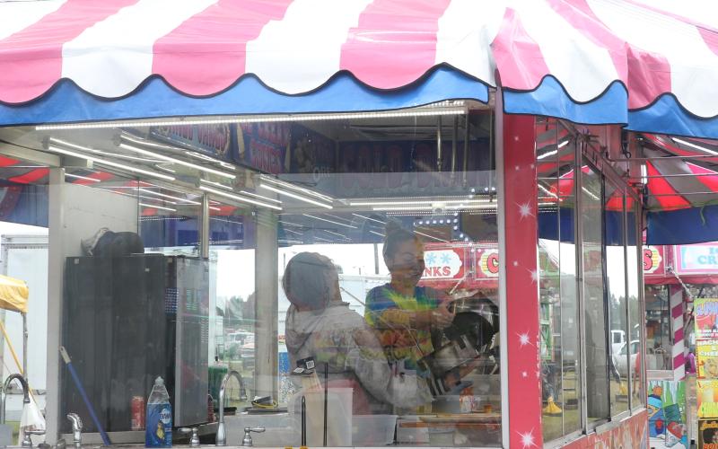 Hannah (left) and Faith Turner share a laugh as they set up a food trailer Thursday afternoon in preparation for opening night of the 67th annual Florida Gateway Fair. (MORGAN MCMULLEN/Lake City Reporter)