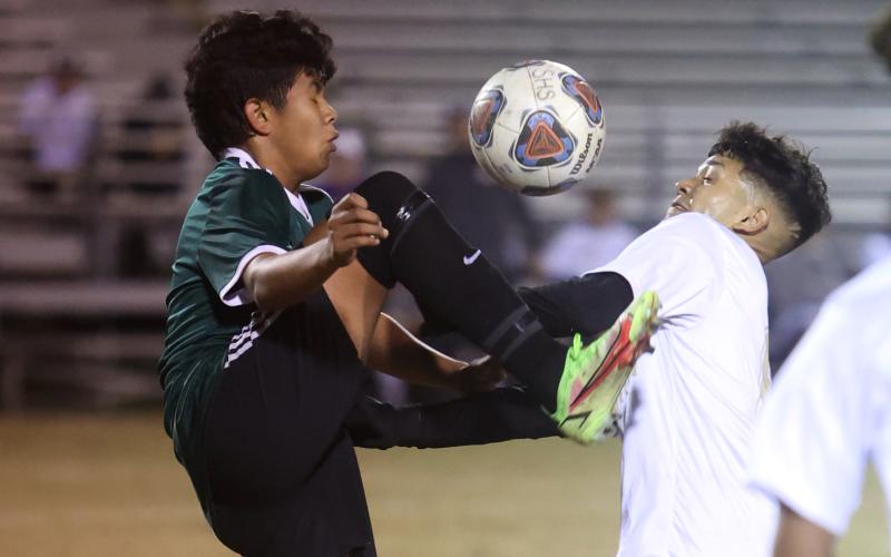 Columbia’s Noel Caballero (right) fights for possession of the ball with a Suwannee player on Tuesday night. (PAUL BUCHANAN/Special to the Reporter)