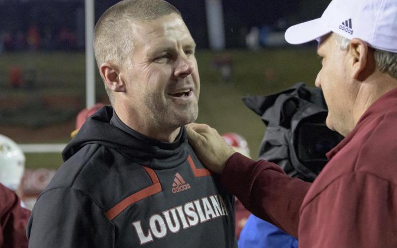 Louisiana-Lafayette head coach Billy Napier is congratulated by Louisiana-Monroe offensive coordinator Rich Rodriguez after Louisiana-Lafayette won 21-16 on Saturday in Lafayette, La. (MATTHEW  HINTON/Associated Press)