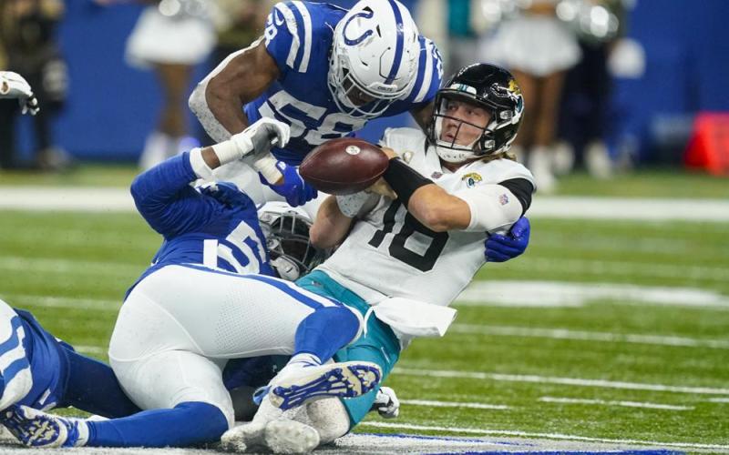 Jacksonville Jaguars quarterback Trevor Lawrence fumbles the ball as he's hit by Indianapolis Colts middle linebacker Bobby Okereke (58) and defensive end Dayo Odeyingbo (54) during Sunday’s game in Indianapolis. (DARRON CUMMINGS/Associated Press)