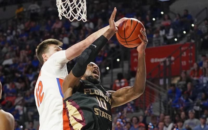Florida forward Colin Castleton blocks a shot by Florida State forward Malik Osborne during Sunday’s game in Gainesville. (JOHN RAOUX/Associated Press)
