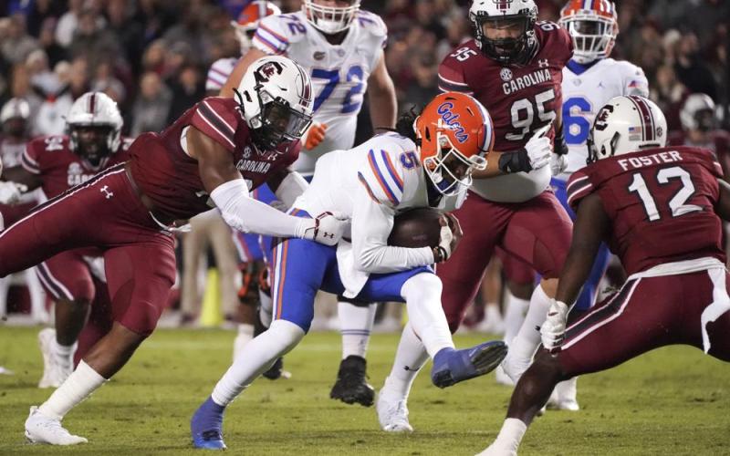 Florida quarterback Emory Jones (5) runs with the ball as South Carolina linebacker Brad Johnson, left, reaches for him during Saturday's game in Columbia, S.C. (SEAN RAYFORD/Associated Press)