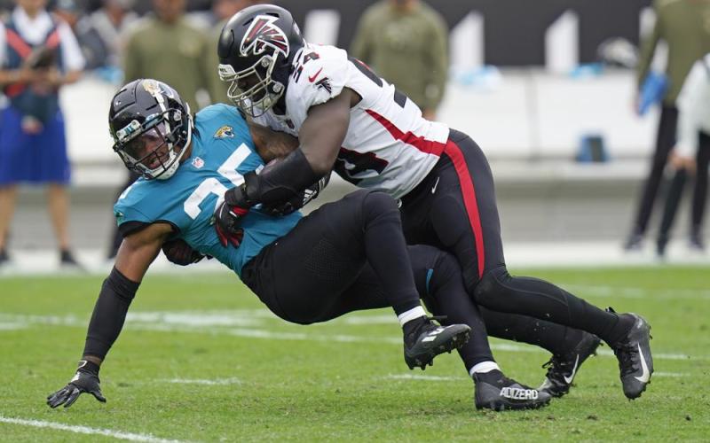 Jacksonville Jaguars running back James Robinson is stopped by Atlanta Falcons linebacker Foyesade Oluokun during Sunday’s game n Jacksonville. (CHRIS O’MEARA/Associated Press)