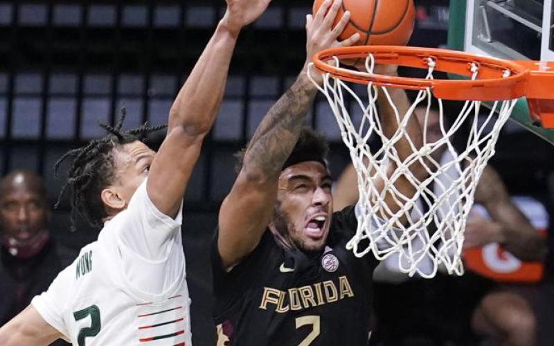 Florida State guard Anthony Polite drives to the basket as Miami guard Isaiah Wong defends on Feb. 24 in Coral Gables. (AP FILE)