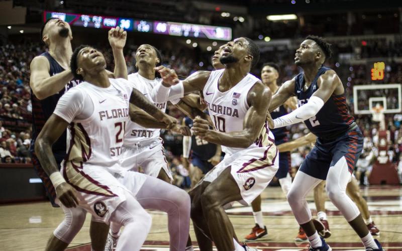 Florida State guard Cam'Ron Fletcher (21), guard Caleb Mills (4) and forward Malik Osborne (10) box out Pennsylvania for a rebound on Wednesday in Tallahassee. (MARK WALLHEISER/Associated Press)
