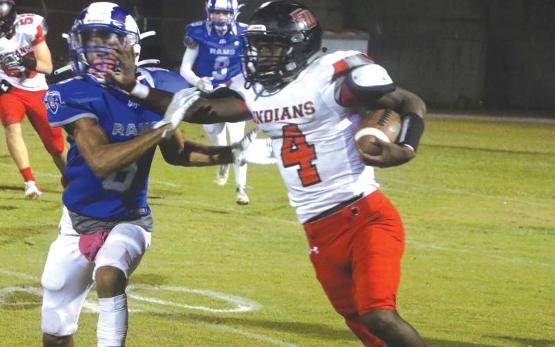 Fort White running back Maliki Clark stiff arms an Interlachen defender on Oct. 29. (MORGAN MCMULLEN/Lake City Reporter)