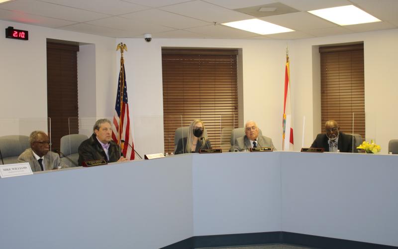Members of the Lake City Council listen to a speaker at the podium during Monday's meeting. (TONY BRITT/Lake City Reporter)