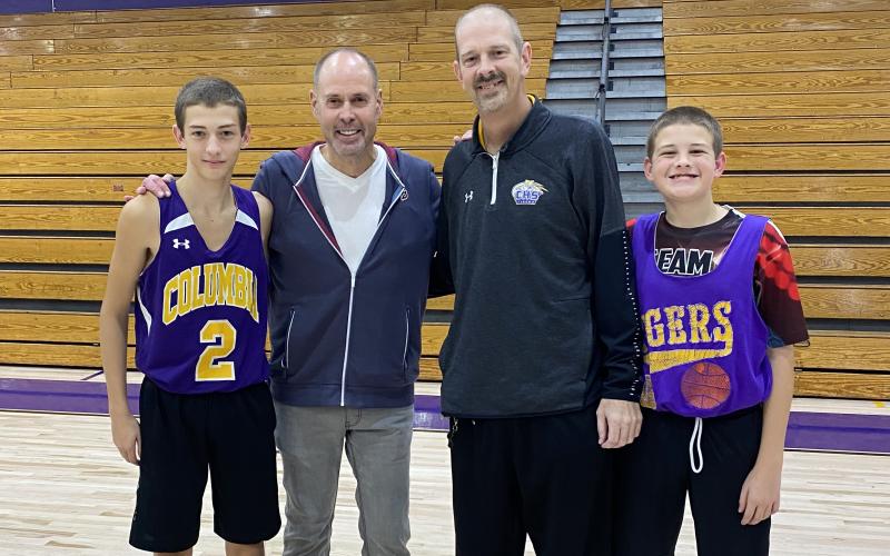 Columbia head coach Steve Faulkner (second from right) and his two sons, Jordan (left) and Tyler (right) are pictured with Ernie Johnson on Wednesday. Johnson made a surprise visit to the school after hearing of Faulkner’s battle with throat cancer. (COURTESY)