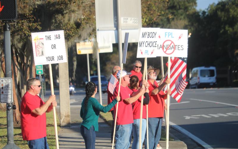 FPL employees and their families protest on the corner of Duval Street and Marion Avenue Wednesday afternoon over vaccine mandates at Florida Power and Light. (TONY BRITT/Lake City Reporter)
