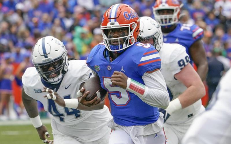 Florida quarterback Emory Jones scores a touchdown on a 31-yard run as he gets past Samford defender Tay Berry, left, and defensive tackle Seth Simmer on Saturday in Gainesville. (JOHN RAOUX/Associated Press)