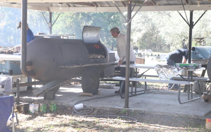 Pork is smoked at the Tustenuggee United Methodist Church on Wednesday, an annual pre-Thanksgiving tradition at the church for 63 years. (MORGAN MCMULLEN/Lake City Reporter)