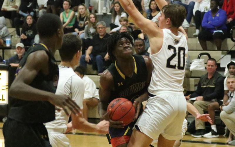Columbia forward Marcus Peterson looks to shoot as Buchholz center Anthony Wilkie defends on Tuesday night. (MORGAN MCMULLEN /Lake City Reporter)