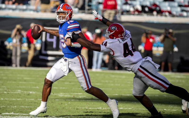 Florida quarterback Anthony Richardson scrambles out of the pocket while being chased by Georgia defensive lineman Travon Walker on Oct. 30 in Jacksonville. (STEPHEN B. MORTON/Atlanta Journal-Constitution via AP)