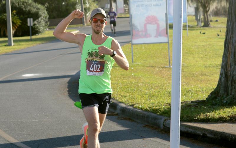 Peter Laughlin crosses the finish line to win the inaugural Turkey Trot 5K at Wilson Park in downtown Lake City on Thanksgiving morning. (JAMIE WACHTER/Lake City Reporter)