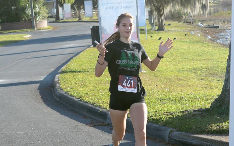 Audrey Fender, the top overall female finisher, crosses the finish line Thursday morning of the inaugural Turkey Trot 5K in Lake City. (JAMIE WACHTER/Lake City Reporter)