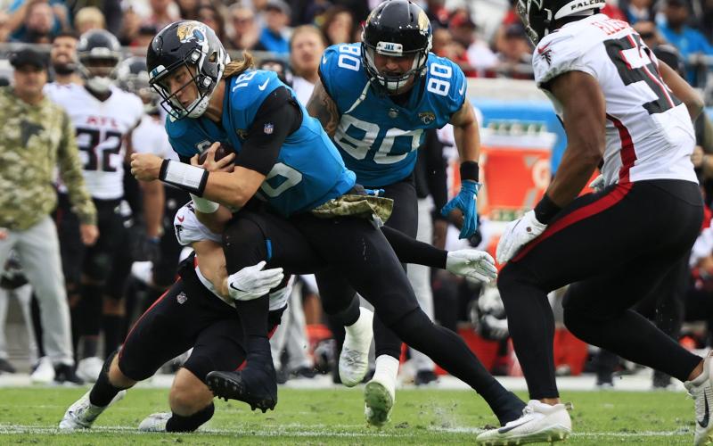 Jacksonville Jaguars quarterback Trevor Lawrence is tackled by Atlanta Falcons safety Erik Harris at TIAA Bank Field on Nov. 28 in Jacksonville. (COREY PERRINE/Florida Times-Union/TNS)
