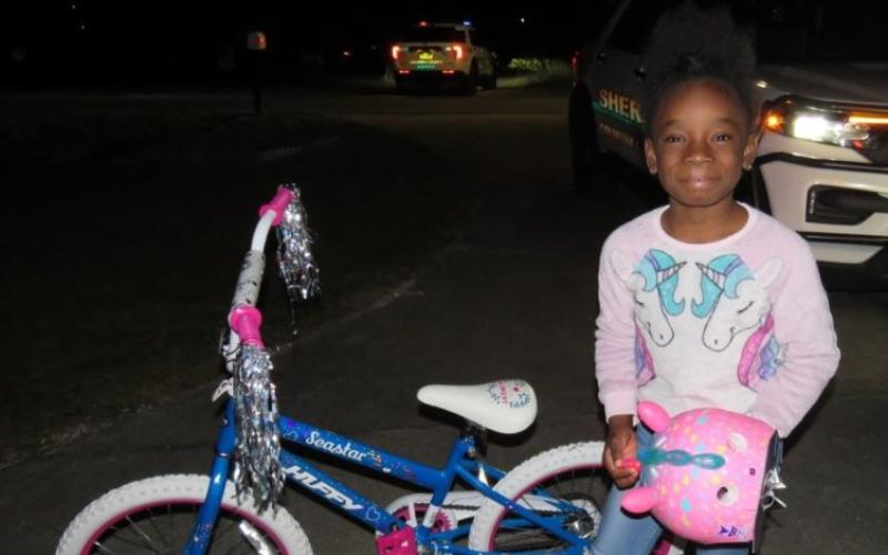 Jy’lar Fudge smiled Saturday night after receiving a new bicycle and a unicorn helmet from deputies with the Columbia County Sheriff’s Office. (COURTESY)
