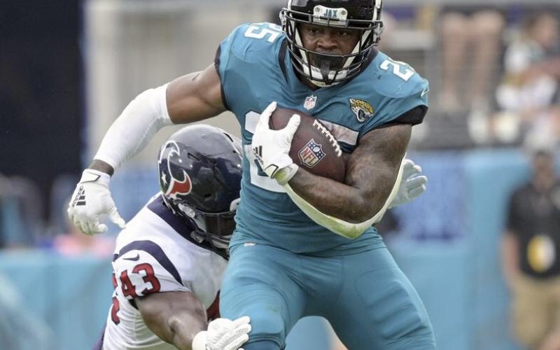 Jacksonville Jaguars running back James Robinson, right, tries to get past Houston Texans middle linebacker Neville Hewitt during Sunday’s game in Jacksonville. (PHELAN M. EBENHACK/Associated Press)