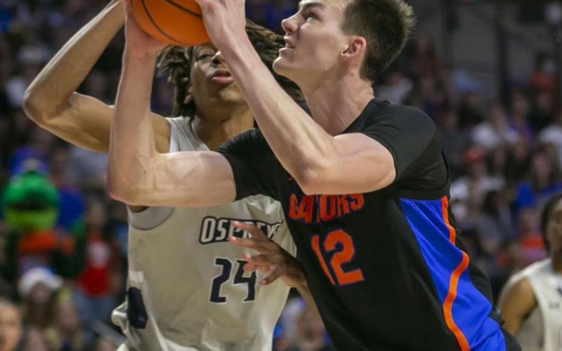 Florida forward Colin Castleton drives on North Florida forward Jadyn Parker during Wednesday's game in Gainesville. (ALAN YOUNGBLOOD/Associated Press)