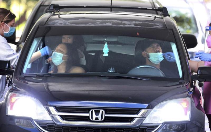 An Orange County family gets tested at the Econ Soccer Complex on the first day of the new covid-19 drive-thru testing site hosted by Orange County Health Services at the park off East Colonial Drive, in Orlando on Dec. 27. (JOE BURBANK/Associated Press)