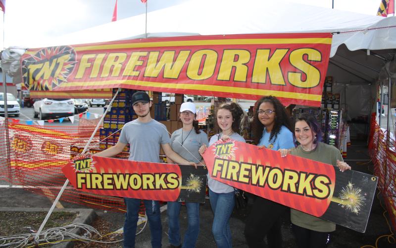 Columbia High School FFA students Logan Russ (from left), Kenzie Dungan, Kaylen Dungan, Cayden Hall and Emili Jones hold two TNT fireworks signs while promoting fireworks sales for the Columbia High School FFA fundraiser. (TONY BRITT/Lake City Reporter)