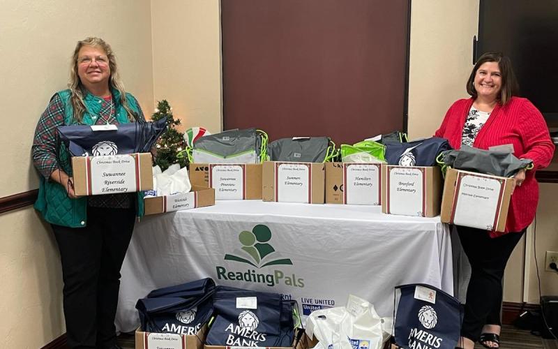 Donna MacRae (left) and Jennifer Lee, with United Way of Suwannee Valley Women United, hold and show boxes of books that go to local elementary school kindergartners during the Christmas break to help improve their literacy skills. (COURTESY)